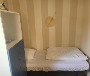Chambre simple avec lit et étagère dans Le petit home d'audrey