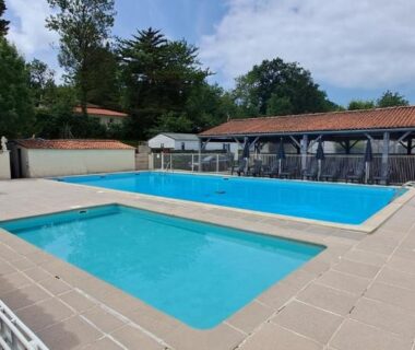 Piscine extérieure avec solarium et parasols du camping Le petit mobilhome de Charlotte à Saint Georges de Didonne