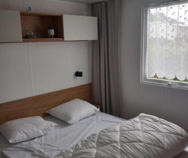 Chambre avec lit double rangements muraux et fenêtre dans L'échapée verte