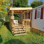 Terrasse couverte en bois avec table et chaises du mobil-home L'échapée verte