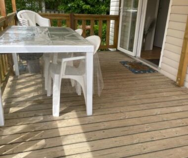 Terrasse en bois avec table et chaises au camping L'échapée verte