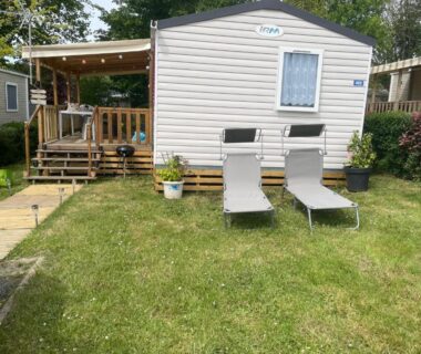 Pelouse devant mobil-home avec deux transats au camping L'échapée verte