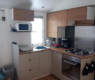 Coin cuisine avec micro-ondes et plaques de cuisson dans le mobil-home de L’échapée verte