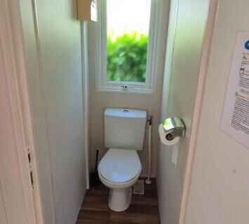 Toilettes étroites avec fenêtre et vue sur la verdure dans L'échappée verte au bord de l'Eure