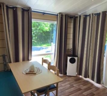 Coin repas avec baie vitrée donnant sur jardin dans le mobil home L’échappée verte au bord de l’Eure
