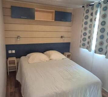 Chambre avec lit double, rideaux et sol stratifié dans L'échappée verte au bord de l'Eure