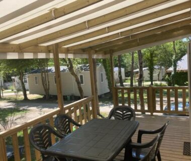 Terrasse couverte avec table et chaises au camping L'écureuil