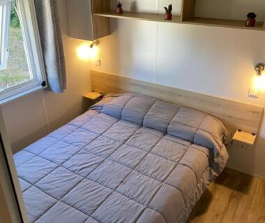 Chambre avec lit double et étagères au camping L'écureuil