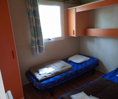 Chambre avec deux lits simples et fenêtre au camping Les 5 Étangs