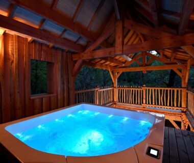 Terrasse couverte avec jacuzzi illuminé au camping Les 7 Montagnes