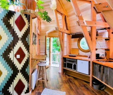 Intérieur en bois avec kitchenette et hublot dans l'hébergement Les 7 Montagnes
