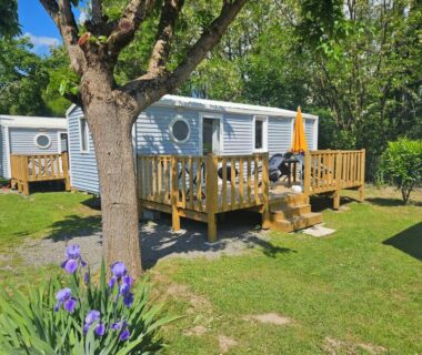Terrasse avec mobil-home et fleurs au camping Les Berges Du Cele