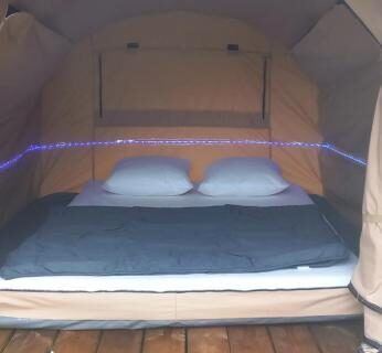 Tente ouverte avec lit sur terrasse au camping Les Berges Du Cele