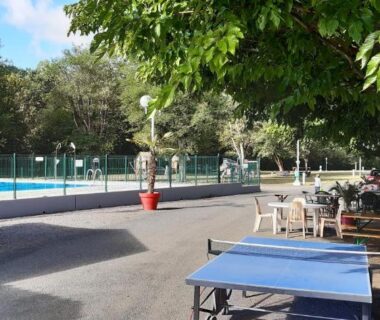 Bord de piscine et terrasses ombragées au camping Les Berges Du Cele