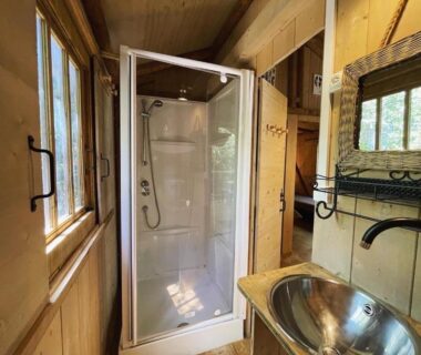 Salle de bains avec cabine de douche et lavabo dans Les Chalets de Labeaume