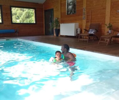 Piscine intérieure avec parent et enfant dans Les Chalets du Lac Belcaire