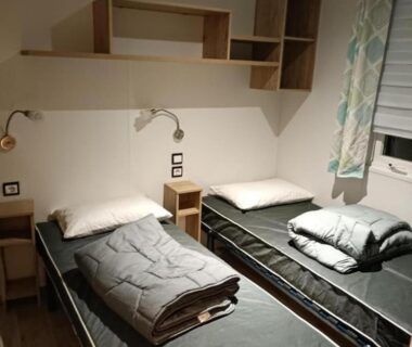 Chambre avec deux lits simples et étagères au camping Les Ch'tis Normands 2