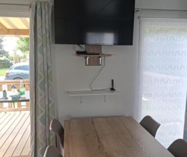 Coin repas avec télévision et terrasse dans l'hébergement Les Ch'tis Normands 2