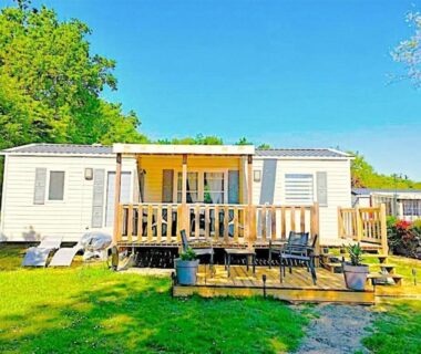 Mobil home avec terrasse en bois et chaises au camping Les Ch'tis Normands 2