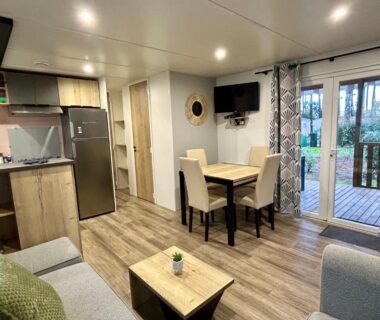 Séjour avec kitchenette et baie vitrée dans le mobil-home Les Dunes d'EZC