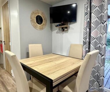 Salon avec table et télévision dans le mobil-home Les Dunes d'EZC