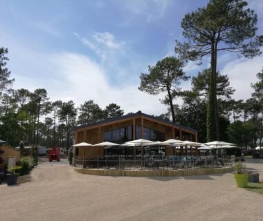 Terrasse avec parasols et tables au camping Les Dunes de Contis 4 étoiles