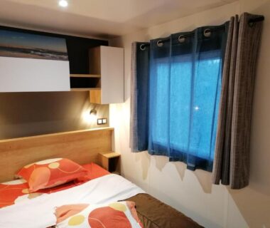 Chambre intérieure avec lit et fenêtre au camping Les Pins del Sol la réserve
