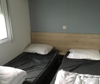 Chambre avec lits simples et rangements du camping Les Sables du Midi