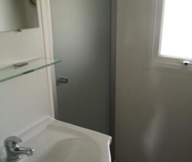 Salle de bain avec lavabo et cabine de douche dans le camping Les Sables du Midi