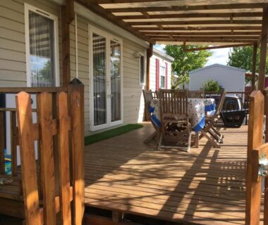 Terrasse en bois avec table et chaises au camping Les Sables du Midi