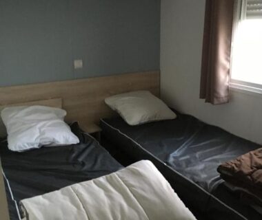 Chambre avec deux lits simples et fenêtre au camping Les Sables du Midi