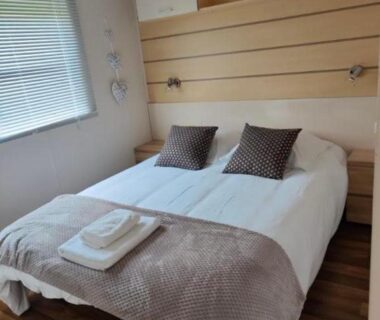 Chambre double avec lit, coussins et serviettes dans les Chalets Salinéens