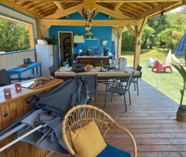 Terrasse couverte avec coin repas et chaises au camping Les chalets Salinéens