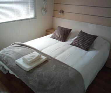 Chambre avec lit double coussins et serviettes dans Les chalets Salinéens