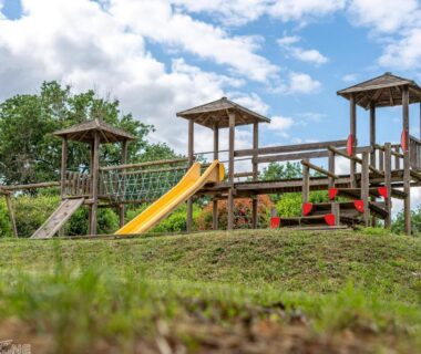 Aire de jeux en bois avec toboggan au camping Les chalets de Dordogne
