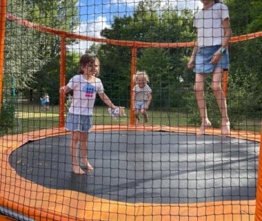 Aire de jeux avec trampoline et enfants au camping Les chalets de fiolles