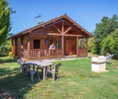 Chalet en bois avec terrasse table et barbecue au camping Les chalets de fiolles