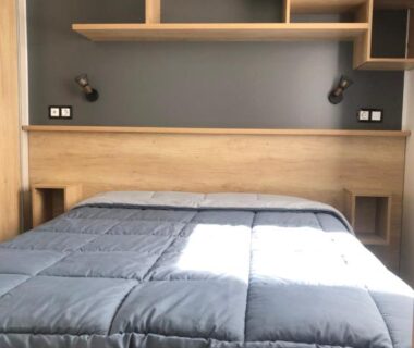 Chambre avec lit double et étagères au camping Les dunes de Contis Chez Edith