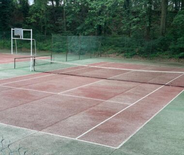 Court de tennis bordé d'arbres au camping Les mobil homes d'oliver rob
