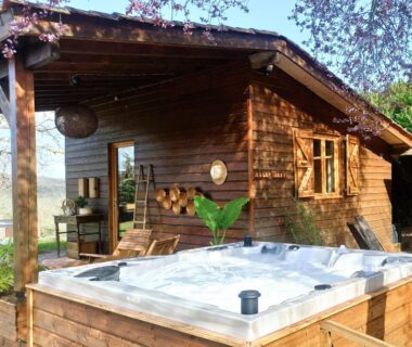 Terrasse en bois avec jacuzzi extérieur au camping Les nids de Bonnan