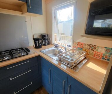 Cuisine compacte avec évier plaques et micro-ondes dans le mobil home Les pieds dans l'Orne