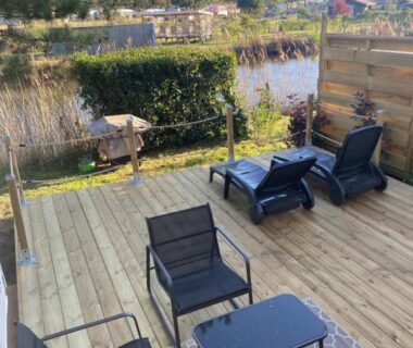 Terrasse en bois avec chaises longues au bord de l'étang Les pieds dans l'eau le coeur en vacances