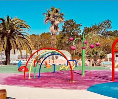 Aire de jeux aquatique avec palmiers au camping Les pieds dans l'eau le coeur en vacances