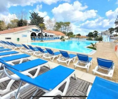 Piscine extérieure bordée de transats au camping Les sables chal’heureux