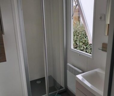 Salle d'eau avec cabine de douche et lavabo dans l'hébergement Les sables du midi