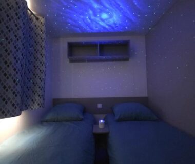 Chambre avec deux lits et plafond étoilé dans le mobil-home Les sables du midi