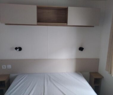 Chambre avec lits et rangement mural au camping Les sables du midi