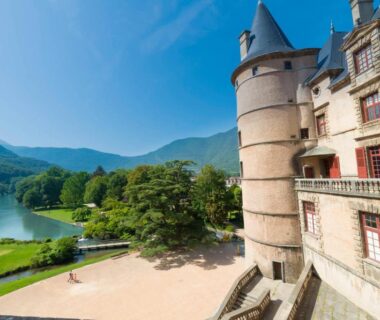 Façade et terrasse du château surplombant le lac en Isère au camping L'imprévu