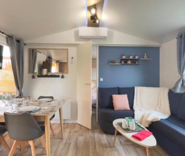 Intérieur avec salon et coin repas lumineux dans L’incontournable Tout Confort Camping Siblu