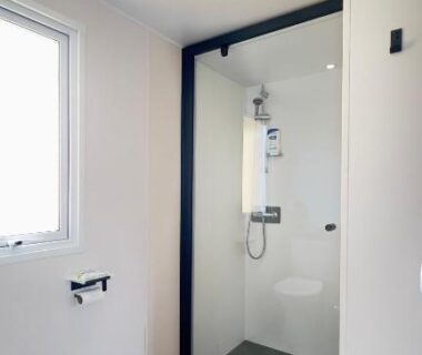 Salle de bain avec douche vitrée et lavabo dans L’incontournable Tout Confort Camping Siblu
